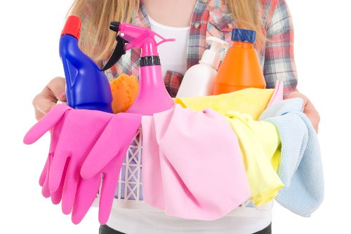 Cleaner treating a living room sofa in Sutton with specialist equipment